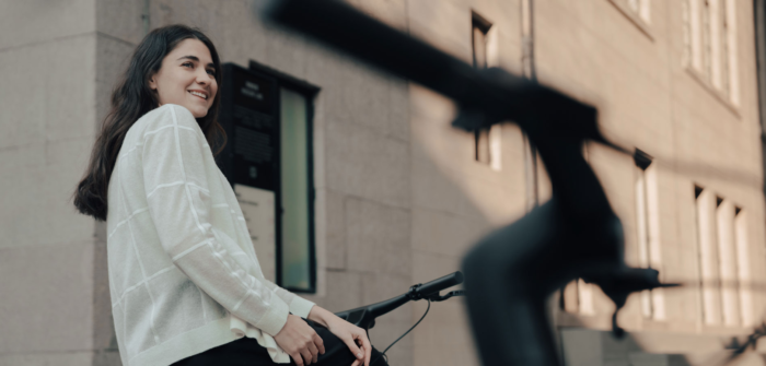 Woman smiles beside Reany e-bike, ready for urban ride.