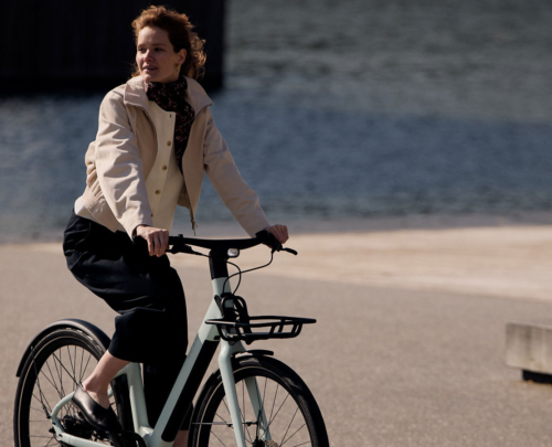 Reany V1 women's e-bike riding near waterfront
