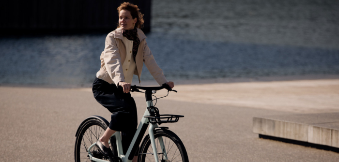 Reany V1 women's e-bike riding near waterfront